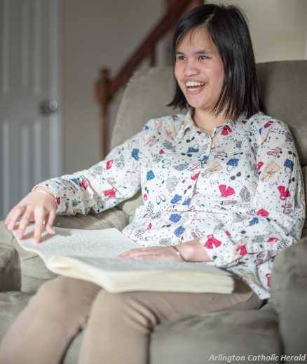 Our client Andrea smiling as she reads the Mass Propers